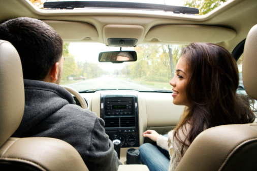 View from backseat of young couple in car